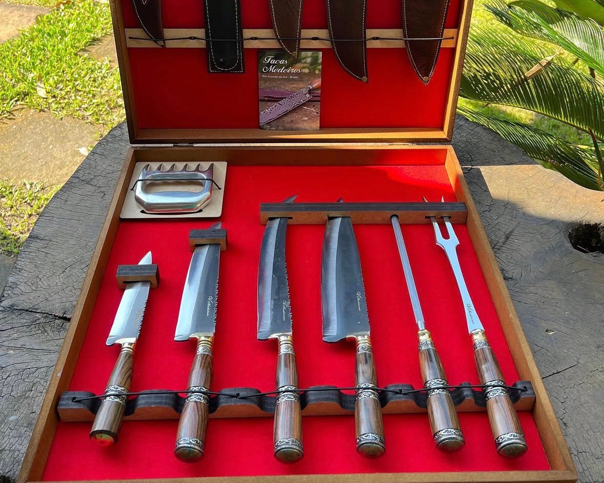 Set of knives in a wooden case with red interior, outdoors.