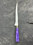 Knife with a purple handle on a gray surface
